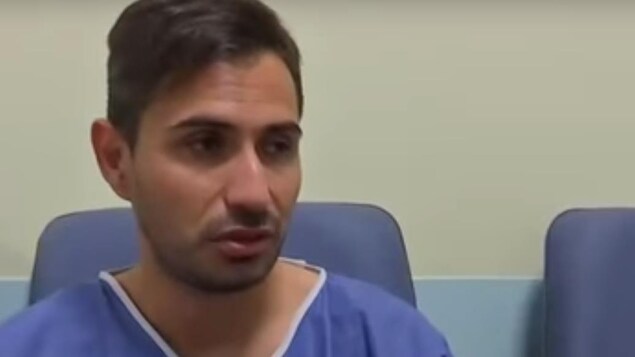 Un plan large de Davide Capello dans sa jaquette d'hôpital Un plan large de Davide Capello dans sa jaquette d'hôpital