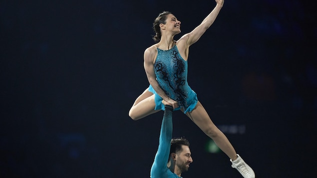 Deanna Stellato-Dudek, soulevée par Maxime Deschamps, fait une figure lors de leur prestation des mondiaux de patinage artistique de Montréal.