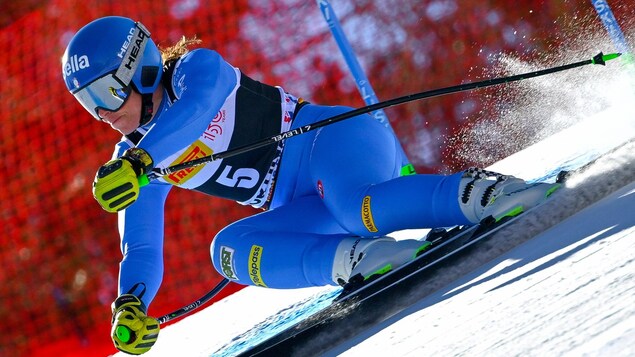 Une skieuse en plein effort dévale une pente de ski pendant une compétition.