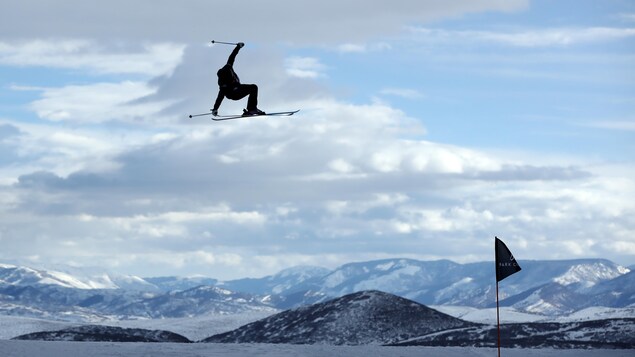 Une skieuse d'élance dans les airs.