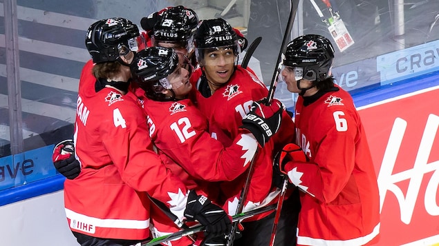 Des joueurs de hockey célèbrent après un but.