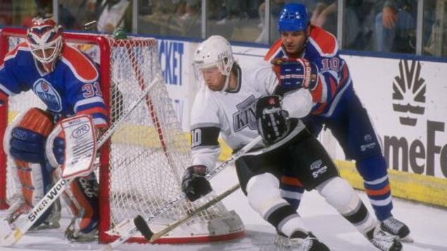 Esa Tikkanen (10), des Oilers d'Edmonton, tente de neutraliser Mike Allison, des Kings de Los Angeles. Esa Tikkanen (10), des Oilers d'Edmonton, tente de neutraliser Mike Allison, des Kings de Los Angeles.