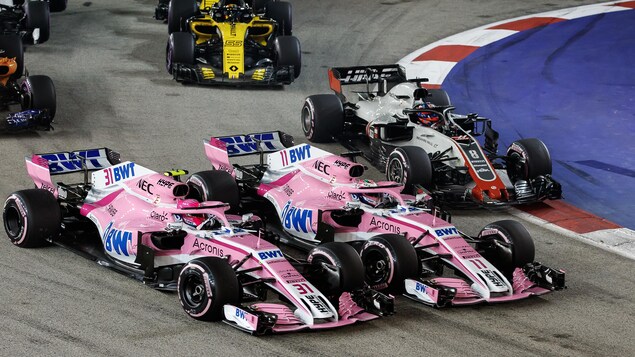 Esteban Ocon (à gauche) tente de dépasser Sergio Pérez au premier tour du GP de Singapour. Esteban Ocon (à gauche) tente de dépasser Sergio Pérez au premier tour du GP de Singapour.