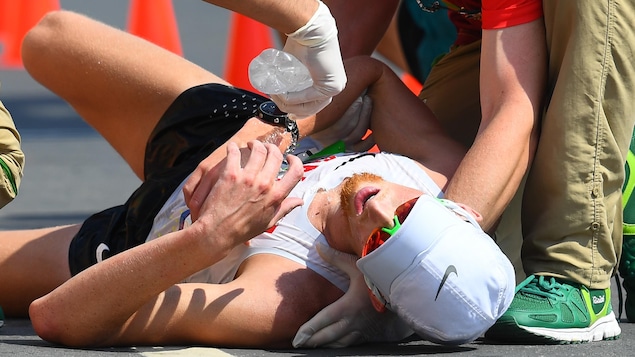 Après s'être écroulé à l'arrivée du 50 km des Jeux de Rio en 2016, le Canadien Evan Dunfee, 4e, reçoit de l'eau des officiels.