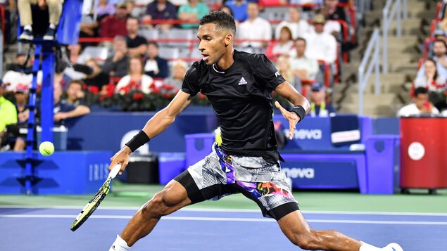 Un joueur de tennis frappe une balle