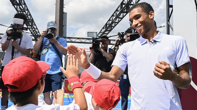 Félix Auger-Aliassime tape dans la main de jeunes partisans devant les médias.