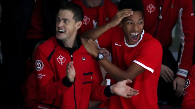Vasek Pospisil et Félix Auger-Aliassime réagissent à un point marqué par Denis Shapovalov en finale de la Coupe Davis à Madrid.
