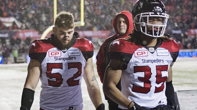Riley Jones (52) et Shaquille Richardson (35) retournent vers le vestiaire après la défaite des Stampeders face aux Argonauts lors du match de la Coupe Grey. Riley Jones (52) et Shaquille Richardson (35) retournent vers le vestiaire après la défaite des Stampeders face aux Argonauts lors du match de la Coupe Grey.