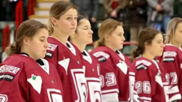 Les joueuses sont alignées sur la patinoire avant la partie.