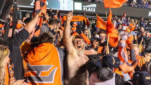 Des partisans sont déchainés dans les gradins lors d'un match de soccer.