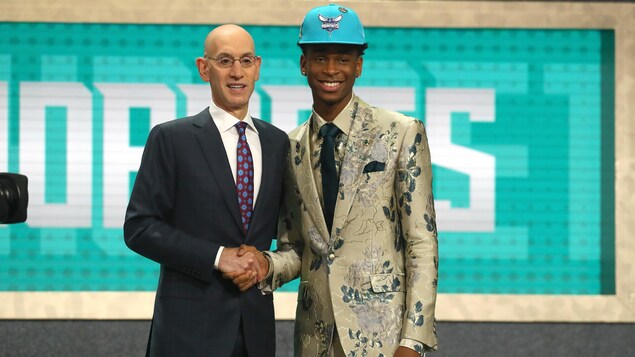Shai Gilgeous-Alexander pose avec le commissaire Adam Silver après avoir été repêché par les Hornets de Charlotte. Shai Gilgeous-Alexander pose avec le commissaire Adam Silver après avoir été repêché par les Hornets de Charlotte.