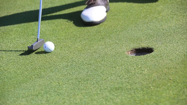 Un golfeur s'apprête à faire un coup roulé.