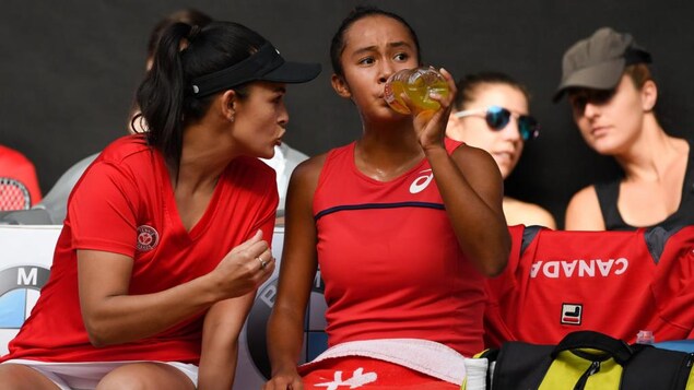 L'entraîneuse donne des conseils à sa joueuse qui boit.