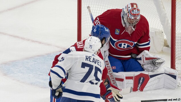 Cayden Primeau arrête la rondelle lancée par Ryan Reaves des Maple Leafs et Arber Xhekaj tente de bloquer le tir.
