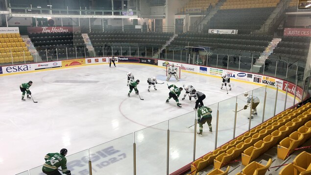 Deux équipes de hockey de la LHJMQ s'affrontent devant des gradins vides.