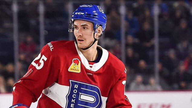 Il regarde à sa droite pendant un match de hockey.