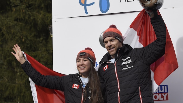 Les athlètes tiennent un drapeau du Canada.