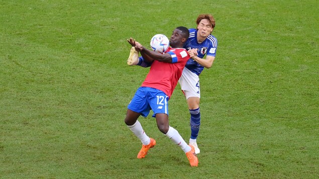 Deux joueurs de soccer tentent de contrôler un ballon.