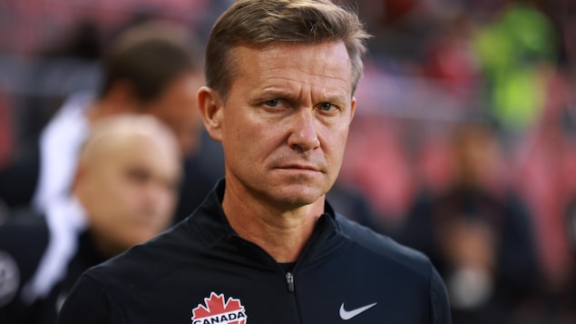 Gros plan sur Jesse Marsch, qui porte une veste avec le blason de Soccer Canada.