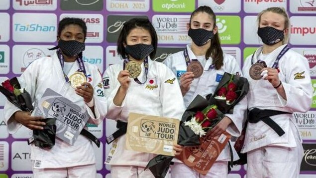 Elles sont sur le podium et posent avec leur médaille au cou.