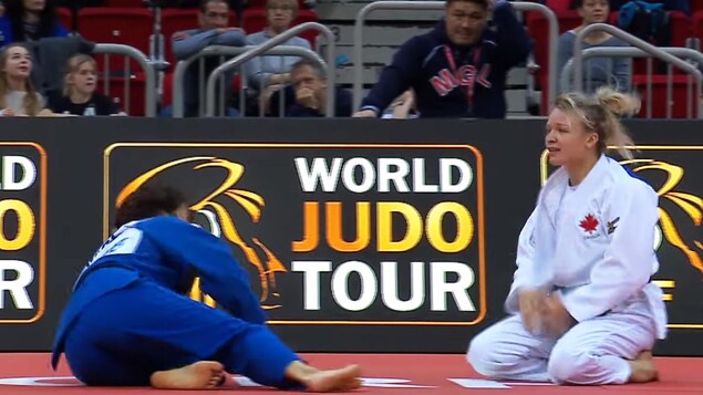 Jessica Klimkait (en blanc) agenouillée sur un tatami face à son adversaire.