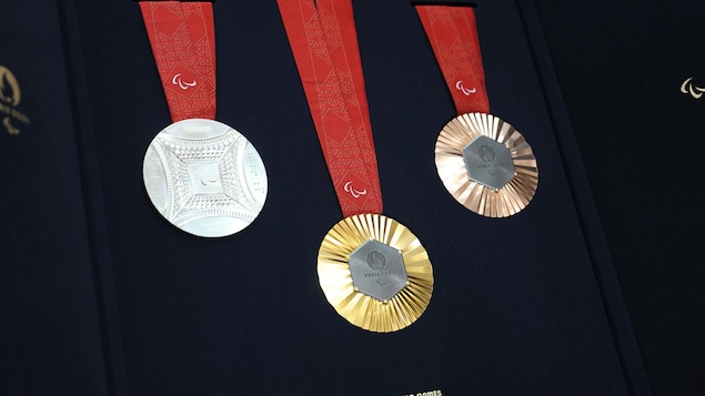 Des médailles d'or, d'argent et de bronze apparaissent sur un plateau de présentation.