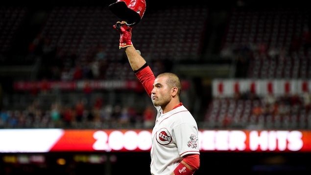Joey Votto lève son casque en l'air pour saluer les amateurs de baseball à Cincinnati.