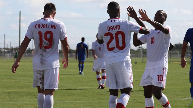Jonathan David est félicité par ses coéquipiers après son premier but dans l'uniforme du Canada. Jonathan David est félicité par ses coéquipiers après son premier but dans l'uniforme du Canada.