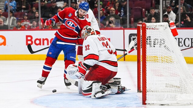 Un joueur de hockey tente de déjouer un gardien.