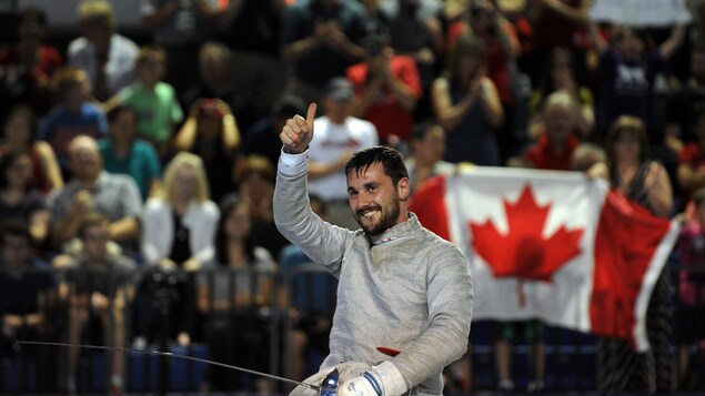 Armée de son sabre, il lève le pouce en l'air devant une foule canadienne.
