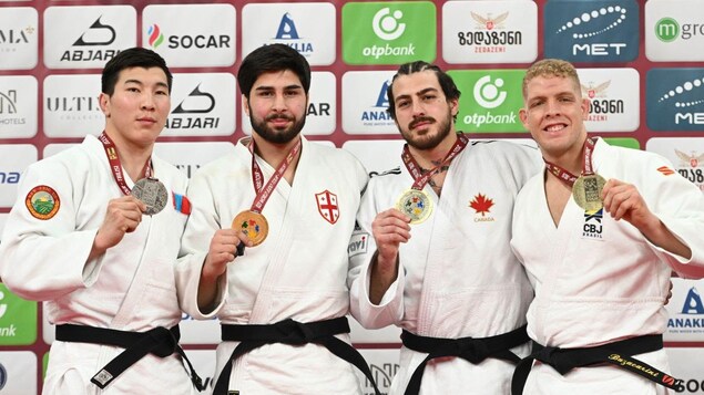 Quatre judokas montrent leurs médailles.