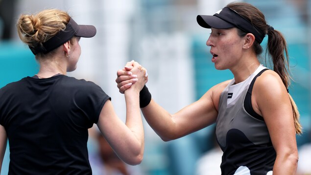 Deux joueuses de tennis se serrent la main.