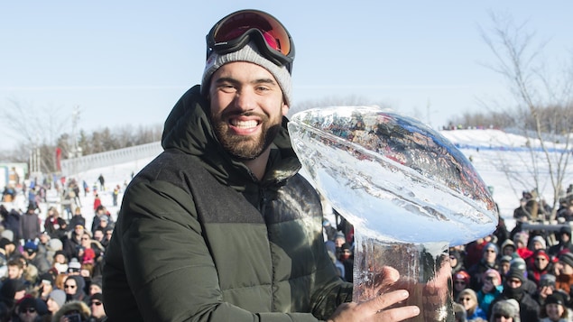 Il fait la pose pour une photo devant une réplique du trophée Vince-Lombardi en glace.