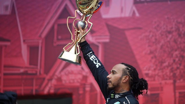 Lewis Hamilton, de profil, soulève le trophée du vainqueur à Sotchi en Russie.