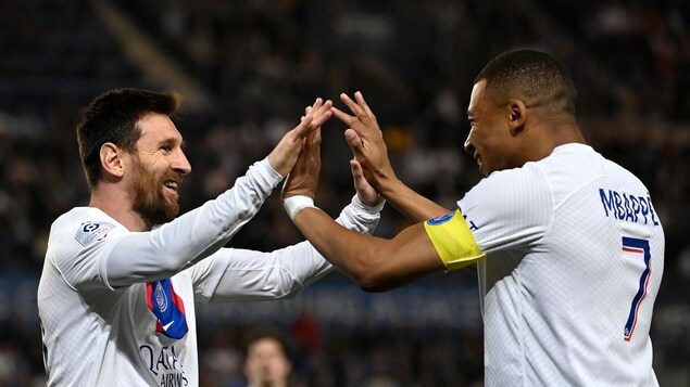 Paris Saint-Germain's Argentine forward Lionel Messi celebrates with Paris Saint-Germain's French forward Kylian Mbappe after scoring his team's first goal during the French L1 football match between RC Strasbourg Alsace and Paris Saint-Germain (PSG) at Stade de la Meinau in Strasbourg, eastern France on May 27, 2023. (Photo by Jean-Christophe Verhaegen / AFP) (Photo by JEAN-CHRISTOPHE VERHAEGEN/AFP via Getty Images)