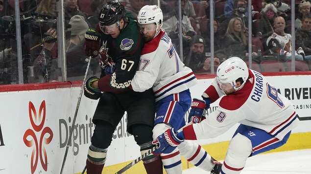 Des joueurs de hockey tentent de prendre possession de la rondelle.