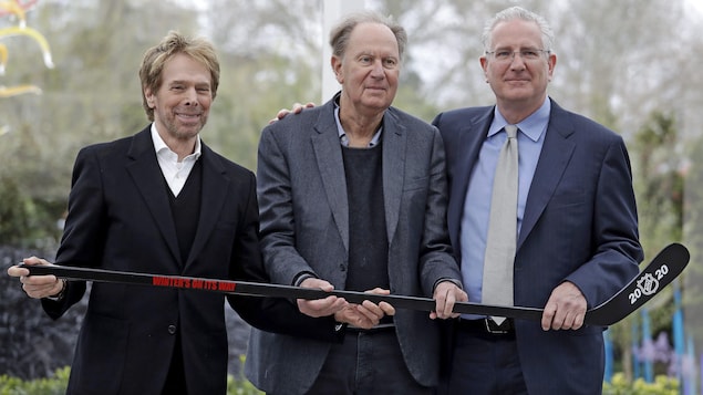 Les trois hommes tiennent un bâton de hockey à l'horizontal. Les trois hommes tiennent un bâton de hockey à l'horizontal.