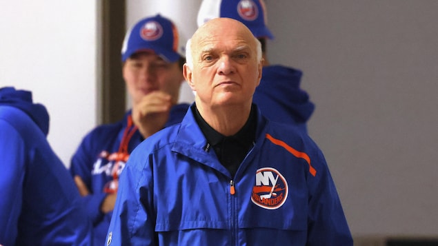 Un homme d'un certain âge porte un manteau avec le logo des Islanders de New York.