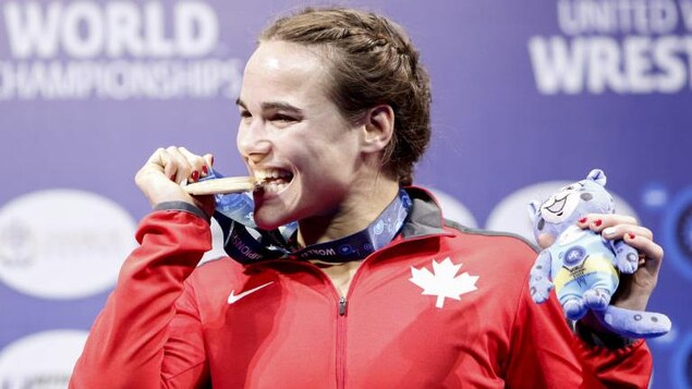 Elle mord à belles dents dans sa médaille d'or.