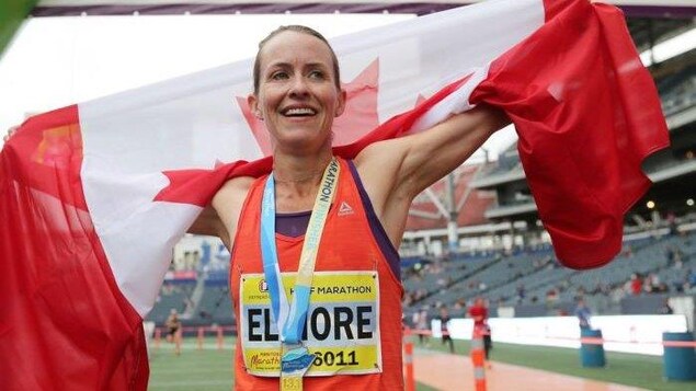 Sourire aux lèvres, elle porte le drapeau canadien sur ses épaules.