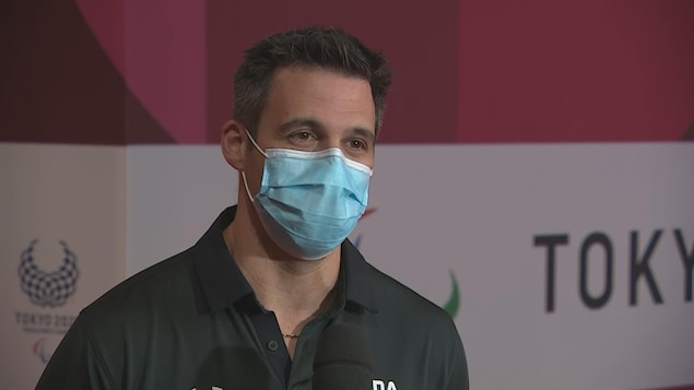 L'entraîneur de l'équipe de basketball en fauteuil roulant Marc-Antoine Ducharme portant un masque et répondant aux questions d'entrevue.