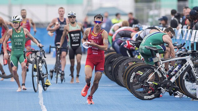 An athlete runs after leaving his bike in the transition area.