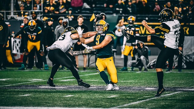 Mathieu Betts court vers le botteur de dégagement des Tiger-Cats de Hamilton pendant un match.