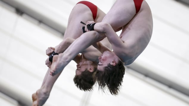 Les deux hommes plongent de façon synchronisée.