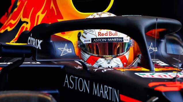 Max Verstappen sort du garage de L'équipe Red Bull dans sa voiture.