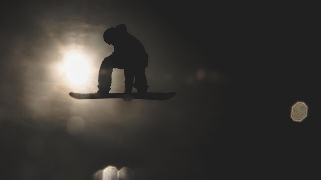 Maxence Parrot effectue un saut en surf des neiges.
