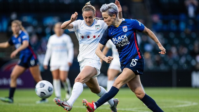 La joueuse Megan Rapinoe frappe un ballon de soccer du pied gauche.