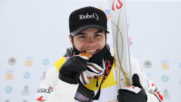 Un jeune homme croque une médaille.