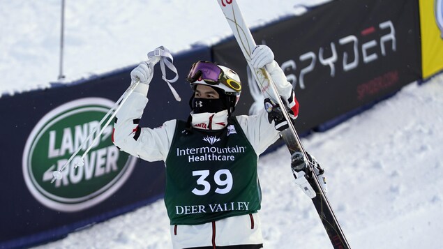 Il lève bras et ski dans les airs.