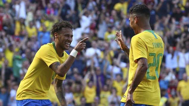 Les Brésiliens Neymar et Roberto Firmino sourient après avoir marqué un but en match amical contre la Croatie. Les Brésiliens Neymar et Roberto Firmino sourient après avoir marqué un but en match amical contre la Croatie.